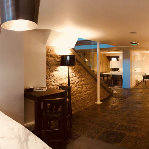 A wide shot of an office with a stone floor and stone walls.