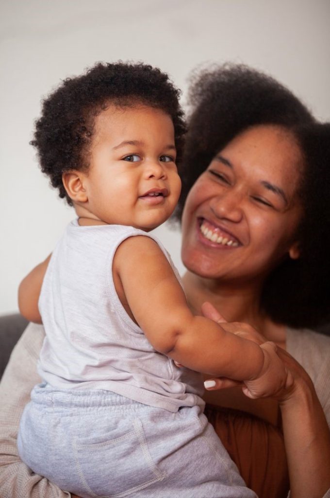 A woman and baby both smiling.