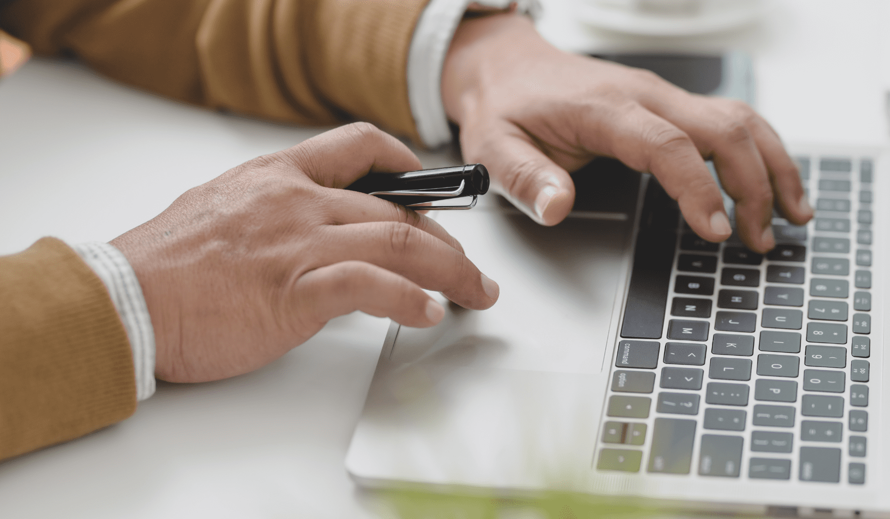 Person's hands typing on laptop