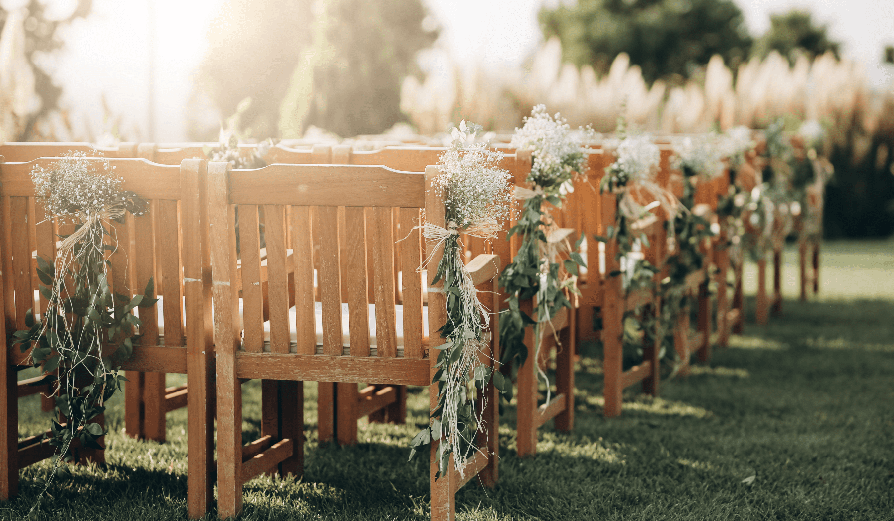 Rows of wooden chairs decorated with flowers
