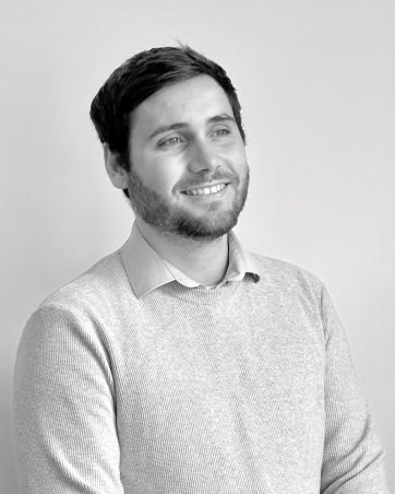 A monochrome, professional picture of a man, a member of the Harbour Family Law team, smiling.