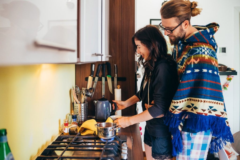 A cohabiting man and woman cooking together.